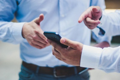 Two Men Looking At A Phone