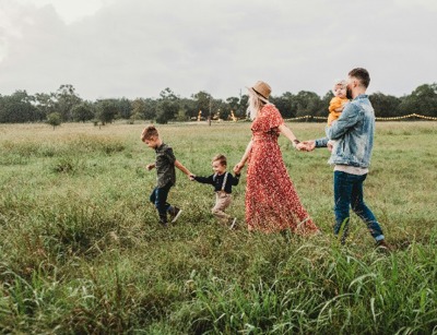 Family Walking Through Field Looking For Homes